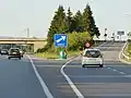 Musoir de sortie d'autoroute, ici en vert avec deux flèches.
