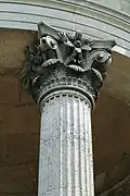 Photographie en couleurs d'un chapiteau de colonne, orné de motifs floraux et de feuilles d'acanthe.