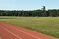 Vue sur la piste d'athlétisme, la colline de Parilly et son château d'eau