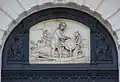 Bas-relief inspiré du tableau de David Teniers le Jeune sur la porte principale.