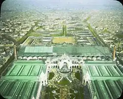 Vue aérienne du Champ-de-Mars avec les toitures, les façades et les fontaines, prise vraisemblablement depuis la tour Eiffel.
