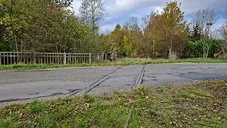 Une ancienne voie ferrée traversant une route.