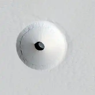 Lucarne de 35 m dans un champ de lave sur Pavonis Mons par le HiRISE.