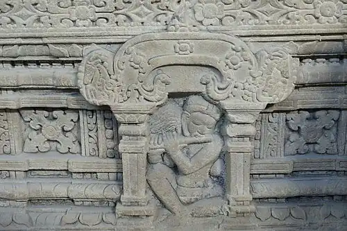 Détail du piédestal, tour sanctuaire E1, Mỹ Sơn: ascète flutiste