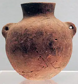 Terre cuite rouge à pâte fine, lissée. Culture de Peiligang, VIe&nbsp;millénaire&nbsp;av. J.-C.. Bouteille de type hu, à deux oreilles verticales perforées pour la corde. H. 11,2&nbsp;cm.Musée de Shanghai.