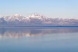 Une vaste étendue d'eau avec au fond de hautes montagnes enneigées.