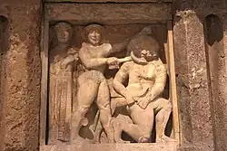 Persée au centre tient Méduse, à droite, dans les mains. Persée n'a pas de bouclier et utilise une épée. Athéna est à gauche.