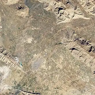 Vue aérienne de la plaine de Marvdasht avec l'extrémité nord-ouest du Kuh-e Rahmat sur la droite.