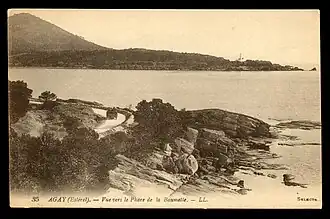 Carte postale noir et blanc. Au premier plan route dans les rochers, au-delà de la mer montagne.