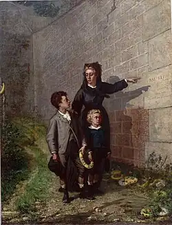 Femme en tenue de deuil montrant le mur à deux jeunes enfants.