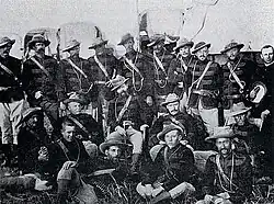 Photographie d'un groupe d'hommes en uniformes militaires avec des chapeaux mous