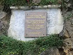 Photographie d'une plaque commémorative posée sur un rocher