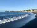 Plage de sable noir à Pīraʻe.