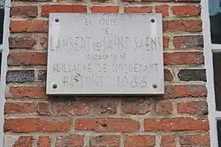 Plaque apposée sur la façade avant de l'ancienne mairie, rue de 31 Août 1944. Il y est écrit : en souvenir de Lambert de Saint-Saëns compagnon de Guillaume le Conquérant Hastings 1066