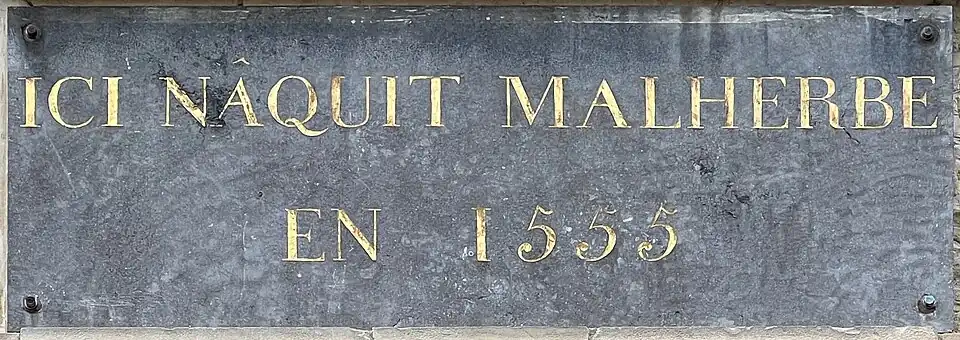 Plaque sur la façade de sa maison natale à Caen.