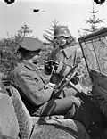 Une soldate polonaise portant un uniforme de la Wehrmacht capturé vérifie des documents (mai 1945).