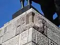 Situé à l’angle du mur sud et est du monument, au sommet du socle, un fragment du premier Monument de Grunwald (avant sa destruction en 1940), intégré dans le nouveau monument reconstruit.