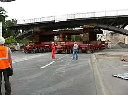 Déplacement de l'ancien tablier, lourd de 650&nbsp;tonnes, vers le chantier de l'entreprise sur des remorques Kamag.