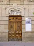 Porte d'entrée au bâtiment avec ses initiales et la date d'achèvement (BMB 1902).