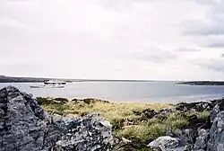 Un bateau de croisière et un chalutier pour la pêche aux calmars dans Port William, vue partir du site proposé pour la construction d'un nouveau port en eau profonde.