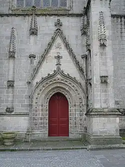 Le portail nord de Notre-Dame de la Chandeleur percé d'une baie en tiers-point et sans tympan, surmontée d'une accolade ornée de choux frisés et amortie par un fleuron.