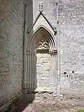 Rouleaux moulurés qui forment l'arc brisé de la porte surmontée par un gâble fleuronné