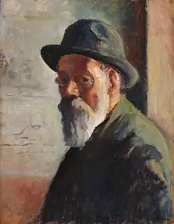 Buste de profil, regard tourné vers le spectateur. Chapeau en arrière, petites lunettes, barbe blanche.