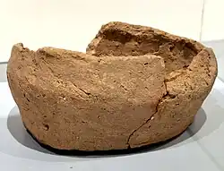 Photographie d'un vase marron fragmentaire.