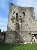 tour rectangulaire en pierre, flanquée d’une porte à mi-hauteur et d’une fenêtre