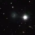 Image de IRAS 23166+1655 prise par le télescope spatial Hubble dans le proche-infrarouge. L'objet brillant à droite est une étoile beaucoup plus proche de la Terre.