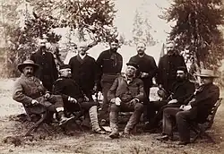 Photographie d'un groupe d'hommes assis dans une foret