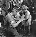 Le soldat canadien MacDonald donne les premiers soins à un enfant