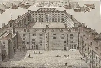 image en noir et blanc, bâtiments doubles avec cours vus de haut, quelques personnes à l'extérieur