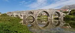 Photographie du pont Arslanagić, se reflétant sur la Trebišnjica.