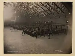 Photo en noir et blanc de militaires en formation à l'intérieur d'un bâtiment