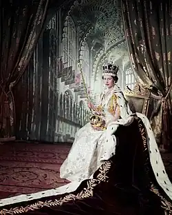 Élisabeth portant une robe et une couronne aux côtés de son époux en uniforme militaire.