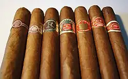 Photo de 7 cigares posés à plat avec leurs bagues.