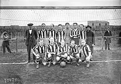 Photographie d'une équipe de football devant un but