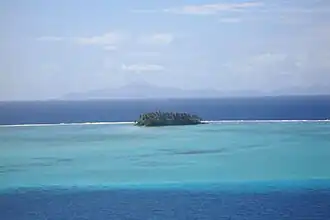 Récif barrière côté lagon, avec un motu.