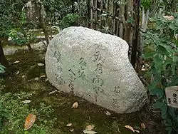 une pierre gravée dans un jardin moussu.