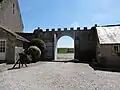 Le portail vu de la cour et l'ancienne porcherie à droite.