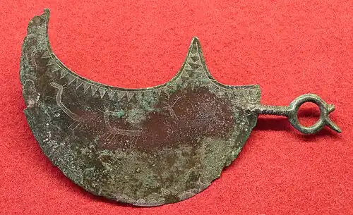 Rasoir lunaire avec scène de chasse gravée, -IXe-VIIIe siècle, provenant de la nécropole villanovienne de Vetulonia. Museo archeologico e d'arte della Maremma.