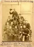 Réunion organisée par la Humbold Sociëteit Minerva : 16 étudiants groupés sur et autour d'une échelle ; entre 1877 et 1885.