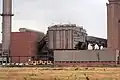De droite à gauche : bâtiment de la chaîne d'agglomération, filtre électrostatique, bâtiment des ventilateurs et cheminée. Usine d'agglomération de Teesside Steelworks&nbsp;(en) en Angleterre.