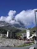 L'église Marie Reine de la Vallée d'Aoste (en latin, Regina vallis augustanæ). À l'arrière-plan, le Cervin dans les nuages.