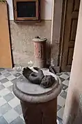 Tronc sous forme de colonne taillée dans du grès, avec en haut la main percée.