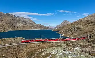 Le Bernina Express longeant le lac blanc, l'un des lacs d'Engadine (canton des Grisons). Octobre 2018.