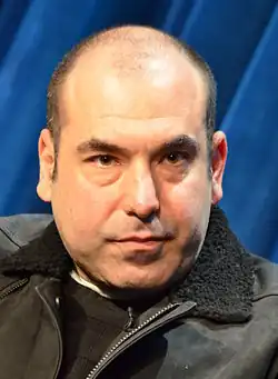 Rick Hoffman incarne Louis Litt.