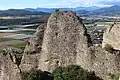Vue rapprochée du poudingue des Pénitents avec la vallée de la Durance en arrière-plan