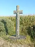 Rosnoën : la croix de Pen-ar-Hoat (Moyen Âge ou XVIe siècle), croix monolithe en schiste portant, en demi-relief, un Christ en croix aux pieds joints.